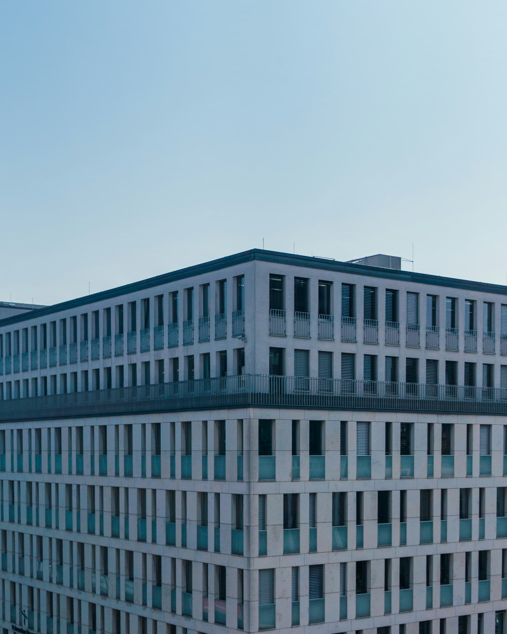 Corner of a large institutional building against a clear sky